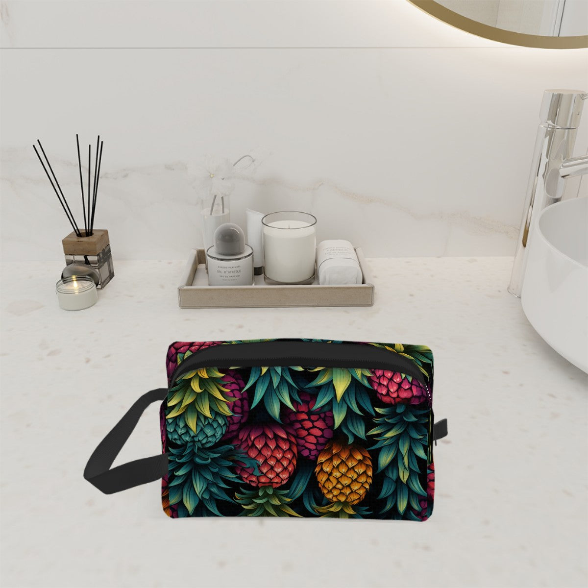 Colorful upside down pineapple toiletry bag sitting on a countertop in the bathroom. Handle to the bag is showing on the left with the zipper part opened.
