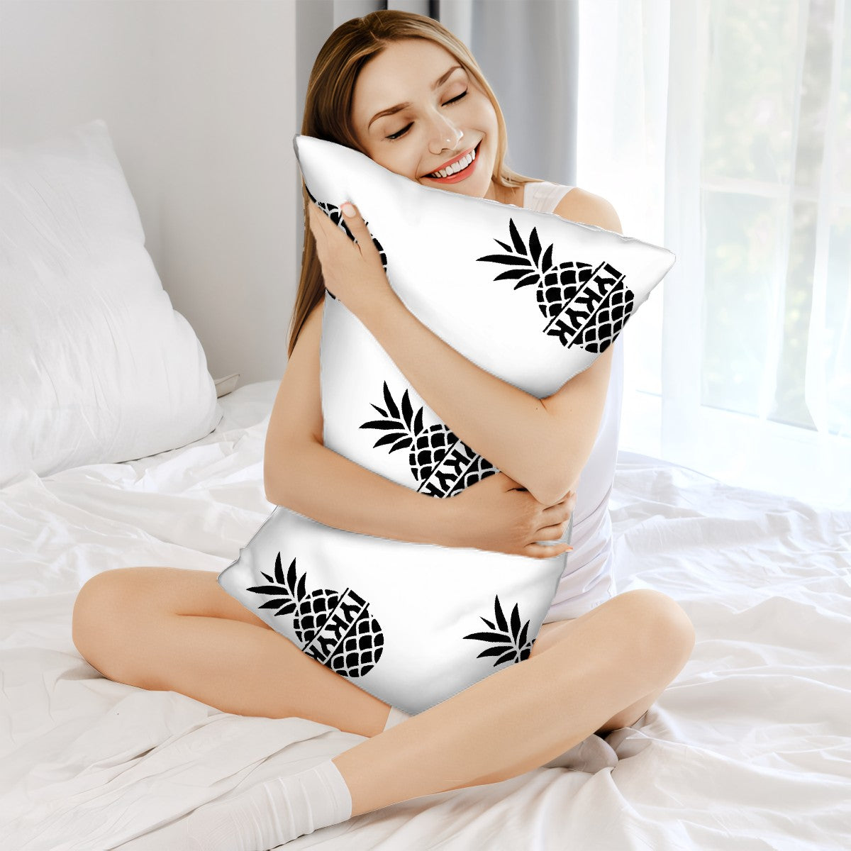 Woman sitting in bed holding a white pillow with an upside down pineapple with the words IYKYK (If you know, you know) on it.