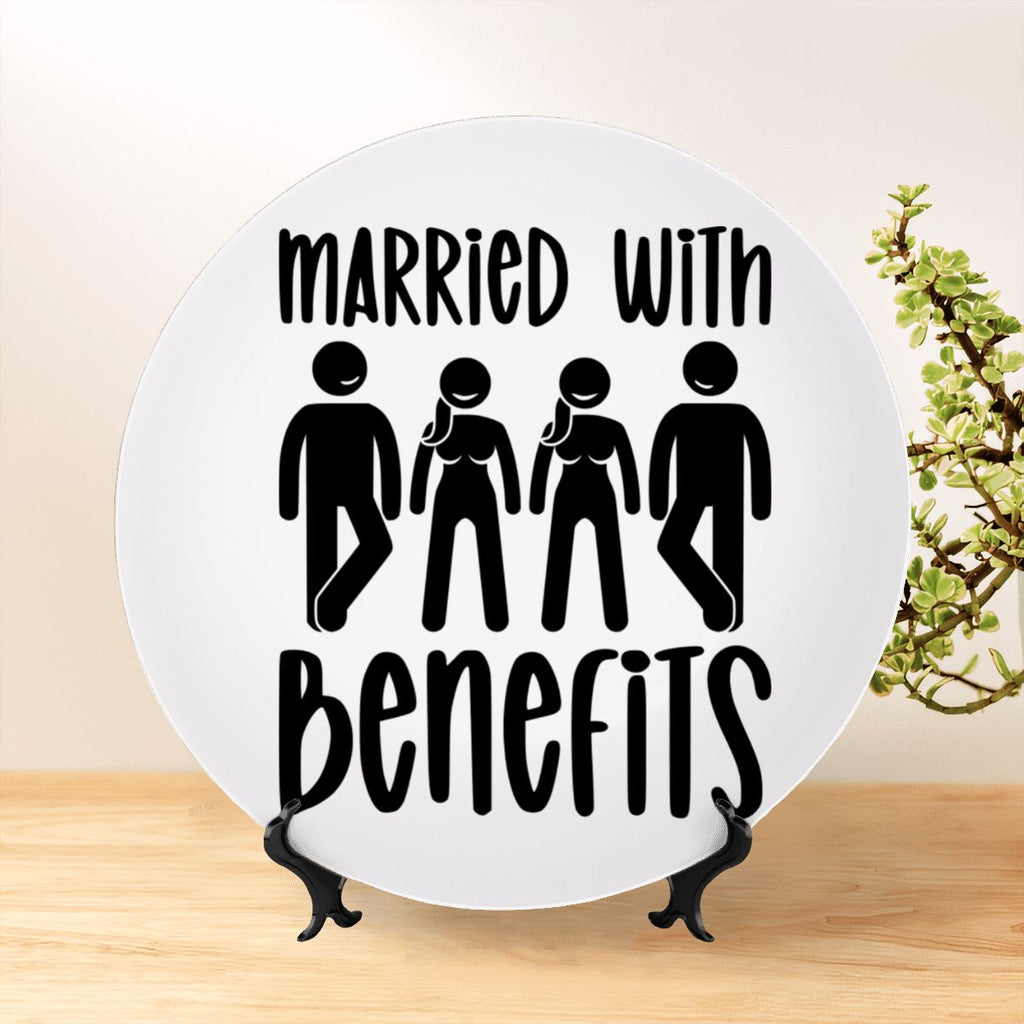 Married With Benefits decorative plate on a stand sitting on a shelf. Depicts two swinging couples in black silhouette on a white plate. Swinger inspired home decor. 